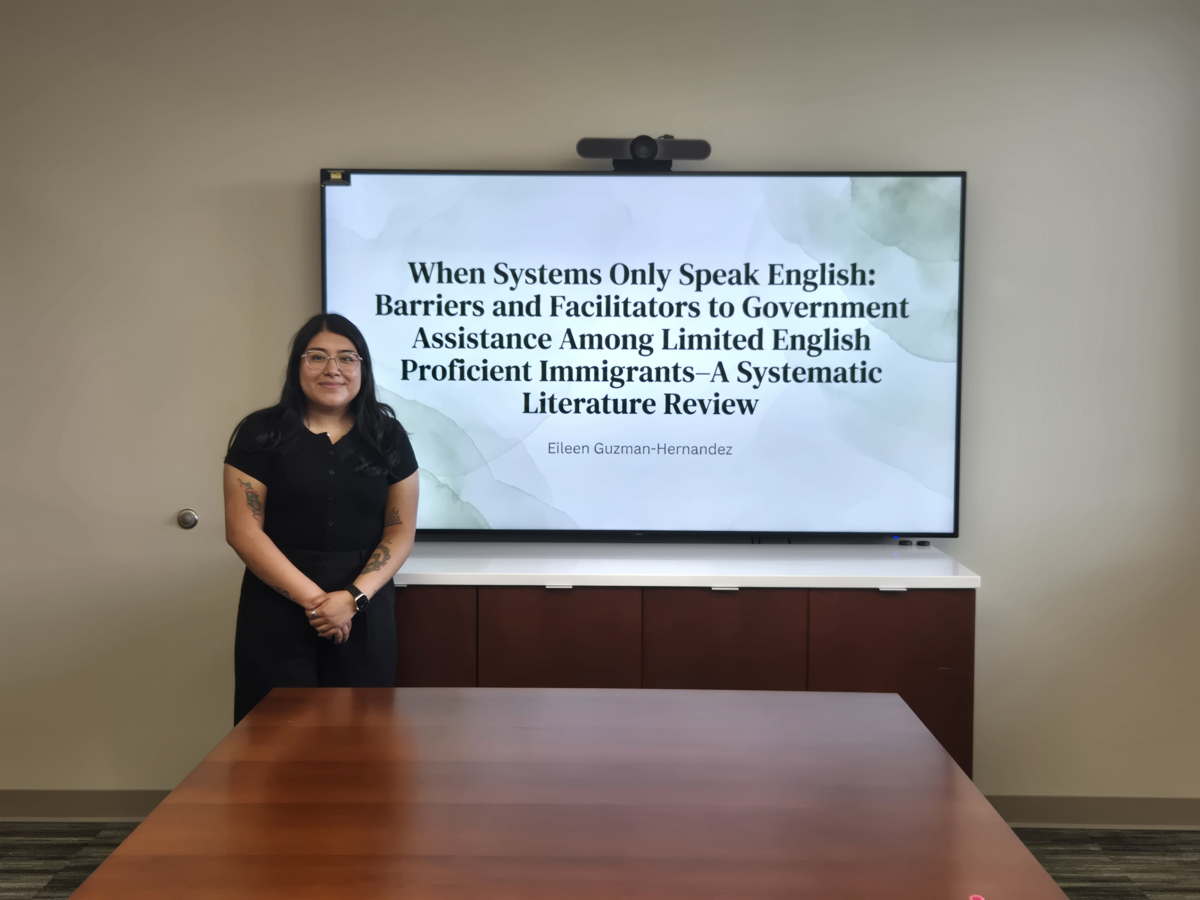 Student stands in front of screen during presentation.
