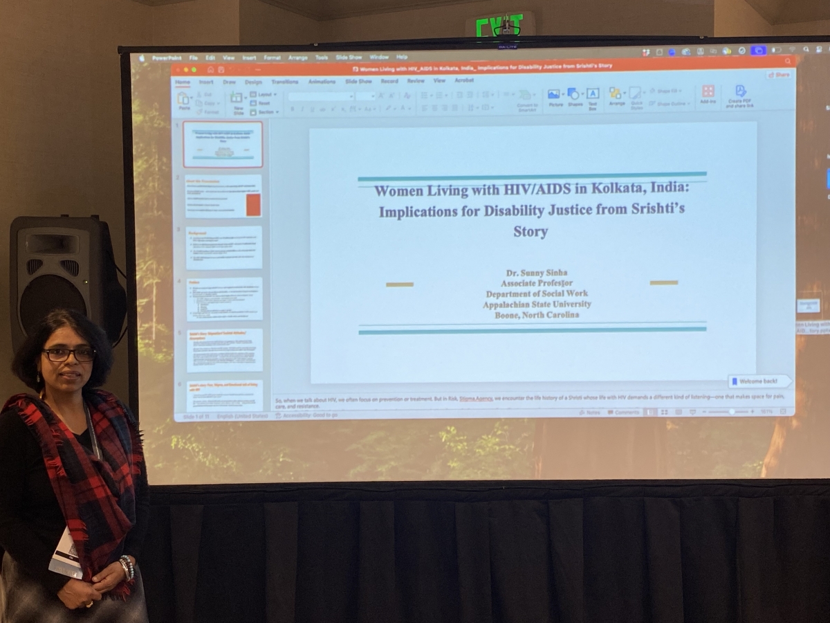 Sunny Sinha in front of screen with presentation